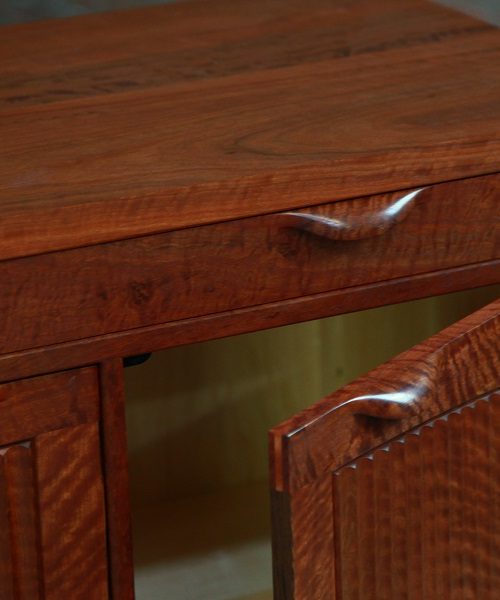 The door of a cabinet in red gum is open to reveal a suprise.