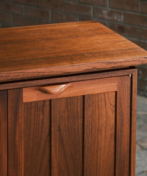 A recently finished red cedar cabinet sits in a woodworking workshop prior to delivery.