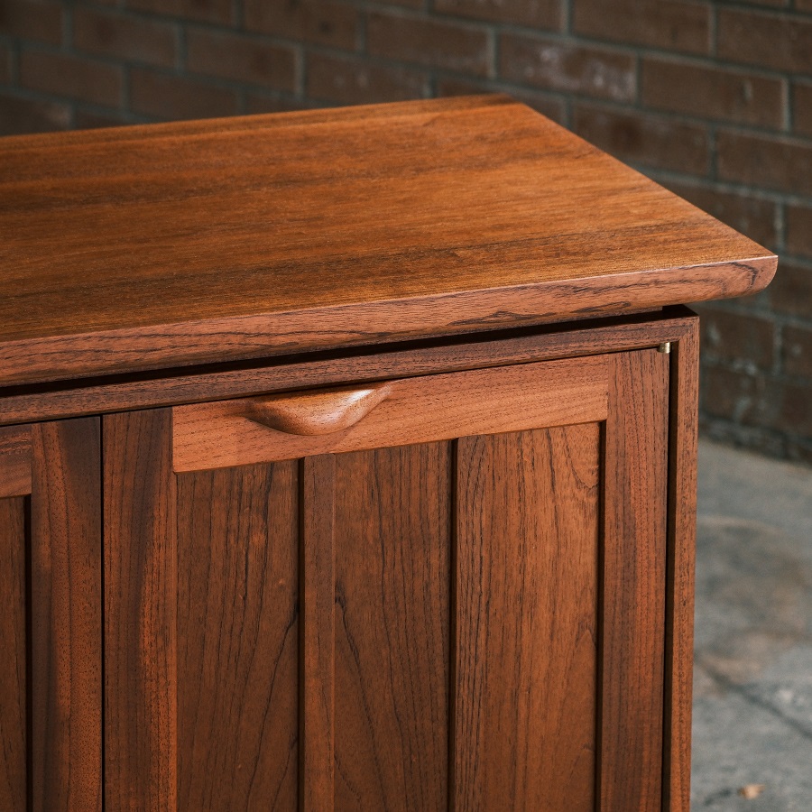 A recently finished red cedar cabinet sits in a woodworking workshop prior to delivery.