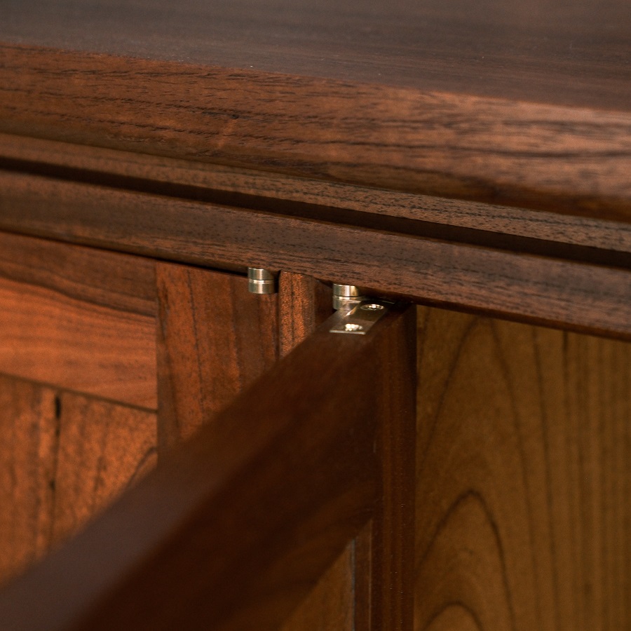 A recently finished red cedar cabinet sits in a woodworking workshop prior to delivery.