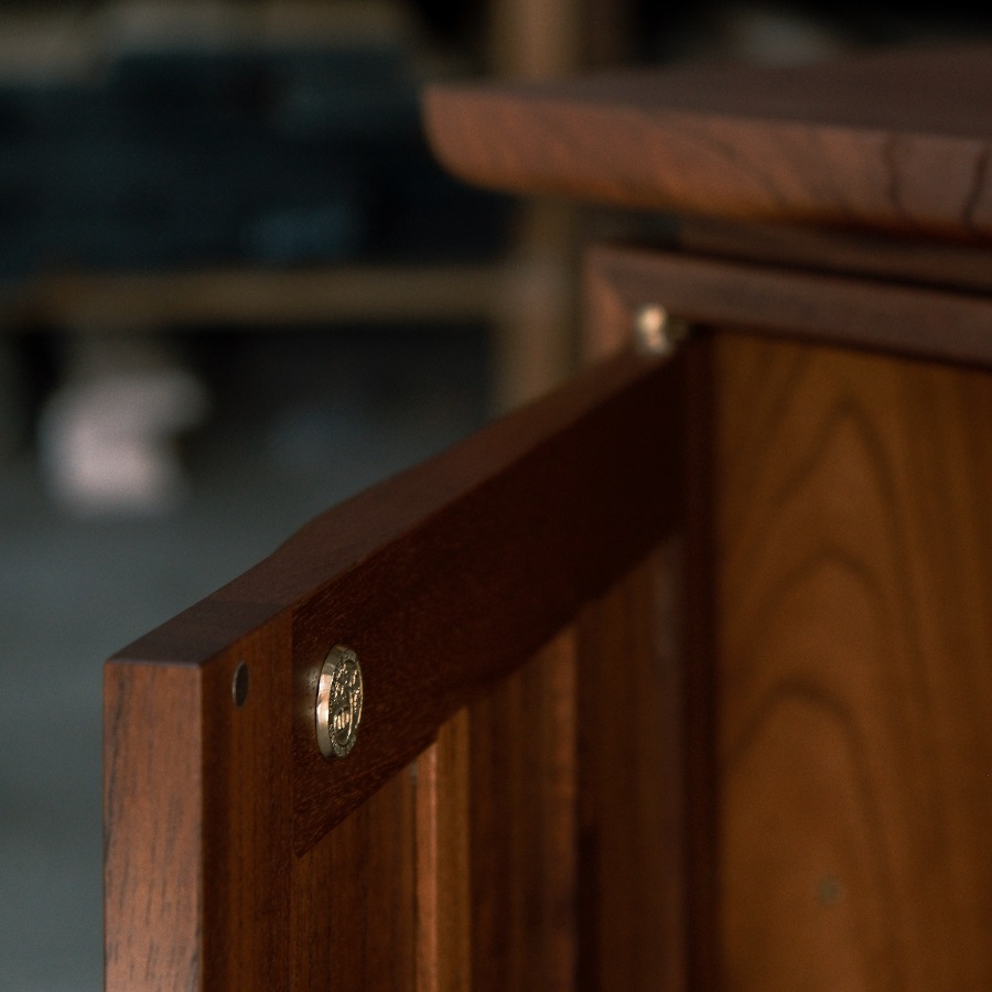 A recently finished red cedar cabinet sits in a woodworking workshop prior to delivery.