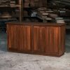 A recently finished red cedar cabinet sits in a woodworking workshop prior to delivery.