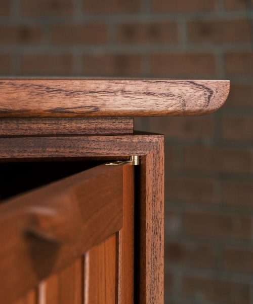 A recently finished red cedar cabinet sits in a woodworking workshop prior to delivery.