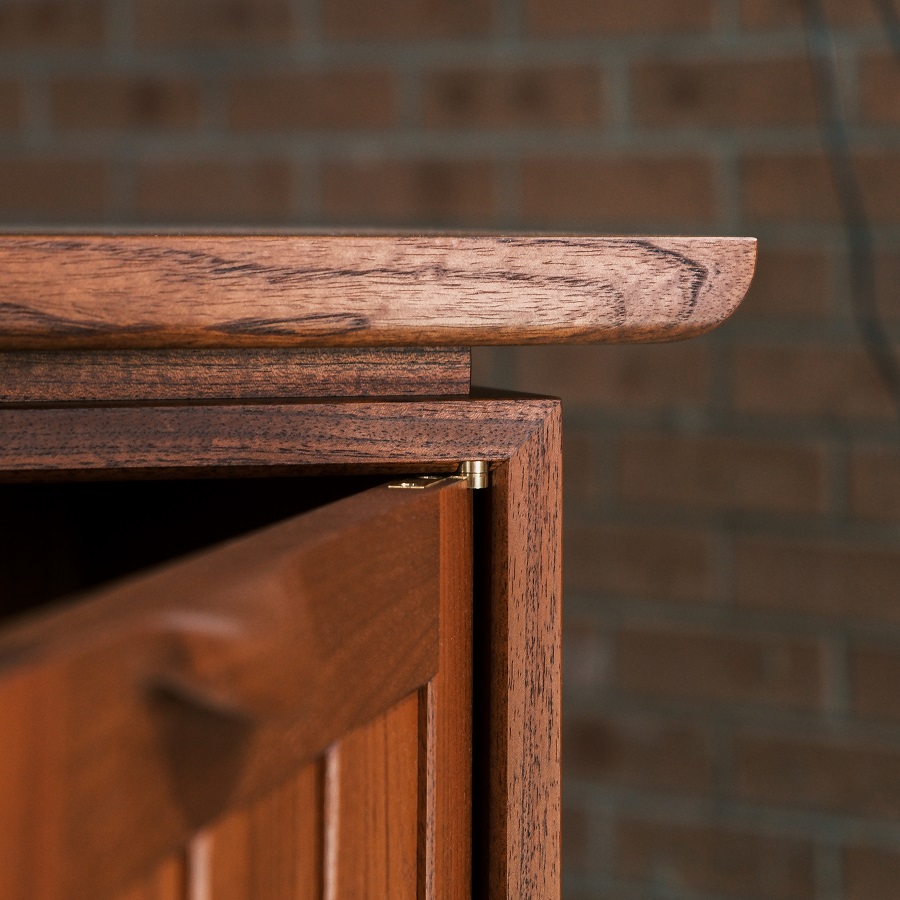 A recently finished red cedar cabinet sits in a woodworking workshop prior to delivery.